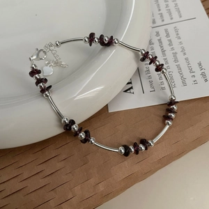 Close-up of S925 sterling silver tube beads and garnet gemstone beads on an elegant bracelet
