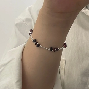 Detail showing handmade S925 silver beaded bracelet with garnet stones on wrist