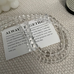 Vue détaillée du collier de perles en cristal blanc sur un tissu blanc texturé élégant