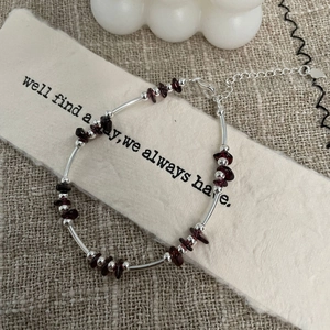 Macro shot of S925 silver beaded bracelet with deep red garnet stones and lobster clasp