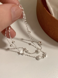 Detailed macro view of S925 sterling silver double-layer star and frosted bead bracelet