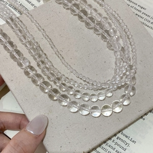 Vue détaillée des perles de cristal blanc transparent sur un sac en lin texturé beige