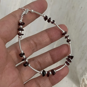 Detail of garnet beaded bracelet with silver tubes, lobster clasp and extension chain