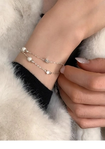 Close-up of double-layer S925 silver bracelet featuring star charms and matte beads on wrist