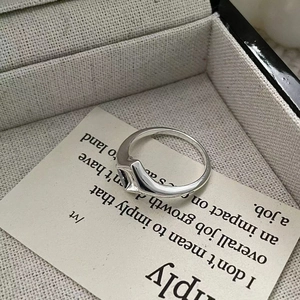 Vue détaillée d'une bague géométrique en argent sur une carte à bijoux beige