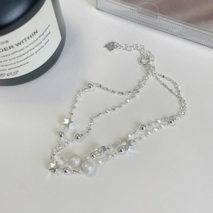 Double-layered S925 sterling silver star bracelet with frosted beads on white surface