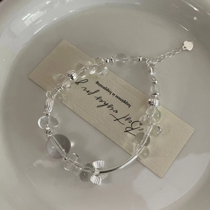 Detail of S925 silver beaded bracelet with clear crystals and a bow pendant