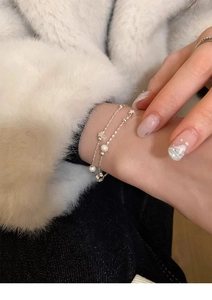 Close-up of double-layered silver star bracelet with frosted beads on a model's wrist
