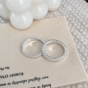 Detailed macro view of S925 sterling silver rings with vertical gear texture on linen