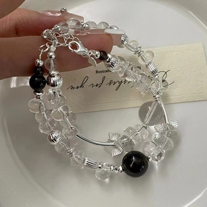 Detail of S925 silver beaded bracelet with white crystals and bow charm on wrist