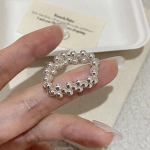 Close-up of a minimalist S925 sterling silver beaded ring with hand-woven texture