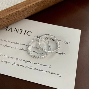 Detailed view of silver stackable rings with beaded texture on elegant vintage props