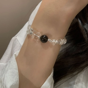 Close-up of beaded bracelet with white crystal and black obsidian on a woman's wrist