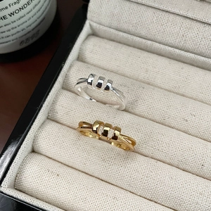 Close-up of gold and silver S925 sterling silver triple-band rings in a jewelry box