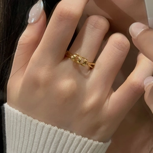 Macro shot of a modern minimalist gold-plated silver ring worn on a finger