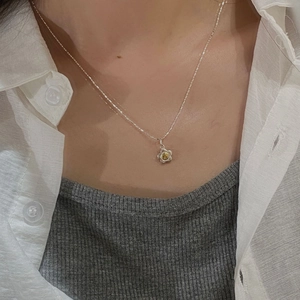 Close-up of S925 silver sunflower necklace with yellow gemstone on model