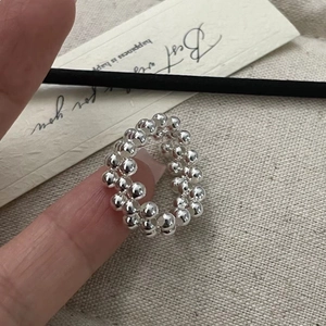 Detailed view of sterling silver beaded ring with textured spherical design on fingers