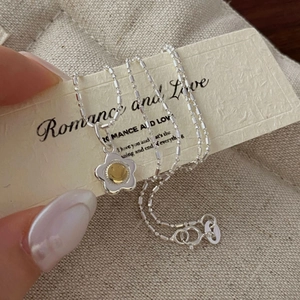 Close-up of S925 sterling silver flower necklace with yellow smiley face pendant