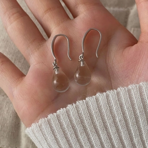 Detail of S925 sterling silver drop earrings with transparent light brown glass charms