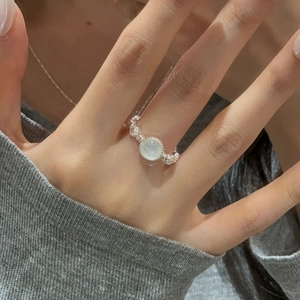Dettaglio anello in argento S925 con pietra di luna traslucida sulla mano della modella