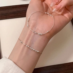 Close-up of minimalist S925 sterling silver beaded bracelet with polished round rings