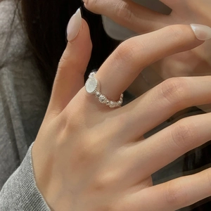 Dettaglio dell'anello di perline in argento S925 con pietra bianca ovale al dito della modella