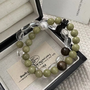 Macro shot of S925 silver beaded bracelet with olive green stones and clear crystal beads