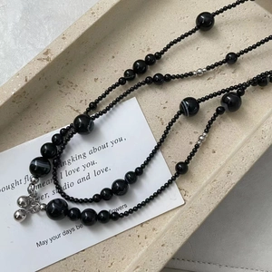 Detail of S925 silver beads and black onyx necklace with polished spheres on stone tray