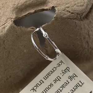 Detail shot of a double-layered S925 silver ring with zircon on a paper texture backdrop