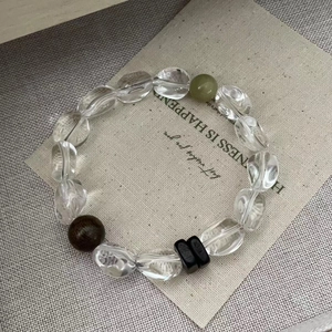 Macro view of S925 silver beaded bracelet featuring green avocado and brown crystals