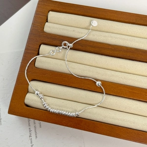 Detail of S925 sterling silver beaded bracelet with adjustable slide clasp and logo tag