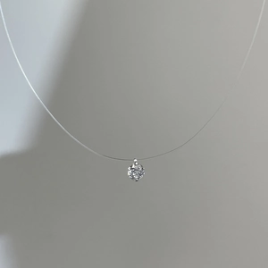 Macro view of a single sparkling round-cut zircon pendant on an invisible nylon fishing line