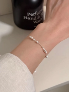 Detailed shot of S925 sterling silver beaded bracelet with knot design on woman's wrist