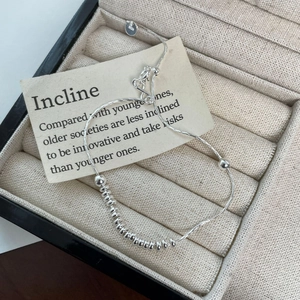 Minimalist S925 sterling silver beaded bracelet on a beige velvet jewelry box display