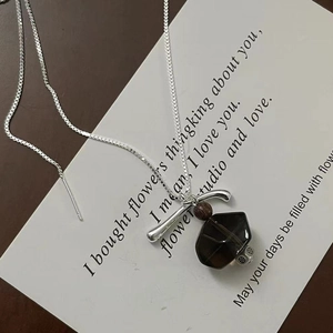 Macro detail of geometric smoky quartz pendant on S925 silver chain with wooden bead