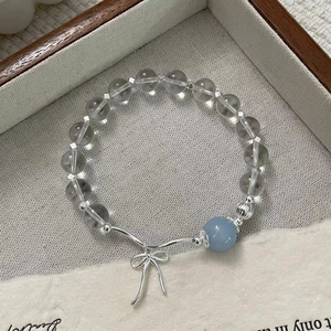 Detail of S925 silver beaded bracelet with blue crystal and delicate bow pendant