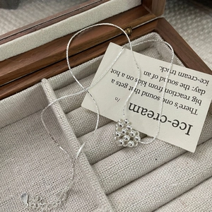 Gros plan d'un pendentif coeur argenté perlé dans un coffret à bijoux en bois luxueux