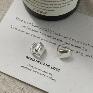 Macro shot of S925 sterling silver square pendant earrings on a card display