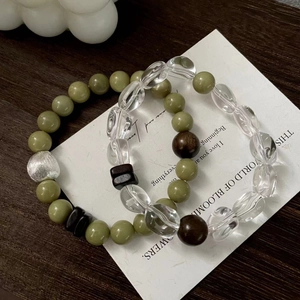 S925 silver beaded bracelet set with green jade style beads and wood beads on wood surface