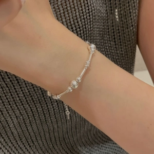 Vue détaillée du bracelet en perles d'argent S925 au poignet avec chaîne d'extension réglable