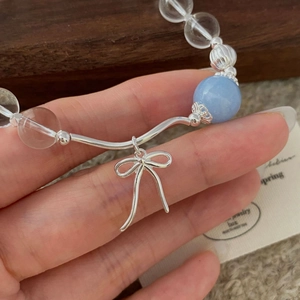 Detail view of S925 silver bracelet featuring clear beads and a blue crystal bow charm