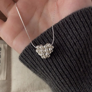 Détail du pendentif cœur en perles d'argent 925 sur une fine chaîne de collier