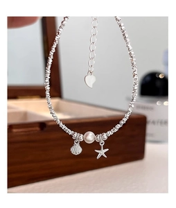 Detail of S925 silver beaded bracelet with starfish, shell charms and natural pearl