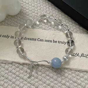 Detailed macro shot of S925 silver beaded bracelet with blue crystal and bow pendant