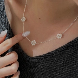 Gros plan détaillé du collier en argent 925 avec trois mini fleurs de perles de nacre