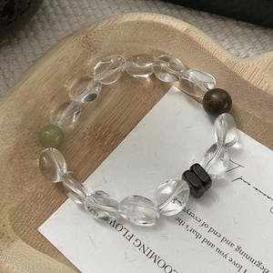Detail view of handmade S925 silver and crystal beaded bracelet on a wooden tray
