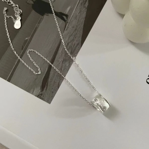 Macro detail of S925 sterling silver cylinder pendant with brushed star pattern