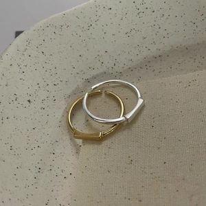 Detail view of gold and silver S925 sterling silver geometric square rings on ceramic