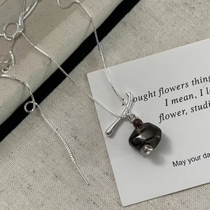 Close-up of S925 sterling silver stamp on a geometric smoky quartz stone necklace