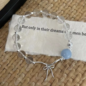 Detail of S925 silver beaded bracelet with blue aquamarine and elegant bow charm